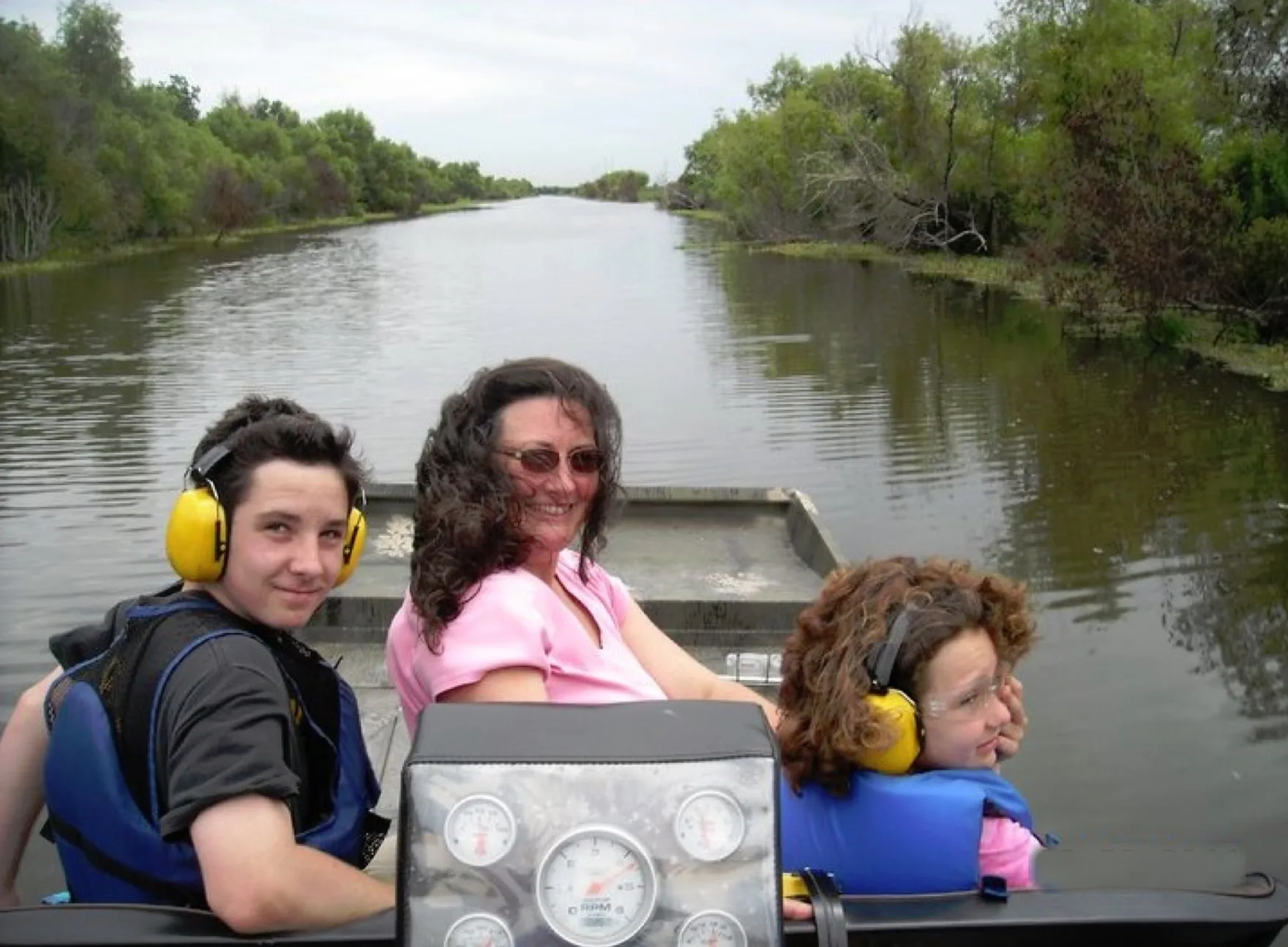 Three guests aboard an airboat in a historical family photograph